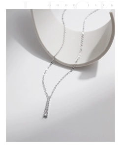 Vertical silver pendant necklace with sparkling cubic zirconia on a modern display