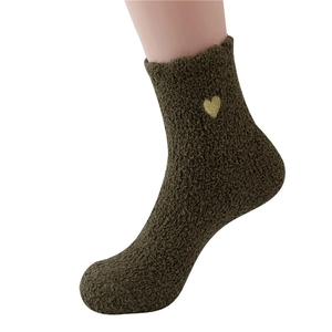 Detailed view of dark green fuzzy sock with delicate gold heart embroidery on the side