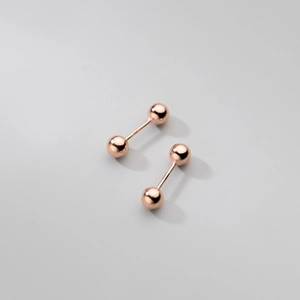 Détails macro des boucles d'oreilles boules en argent S925 plaqué or rose poinçonné