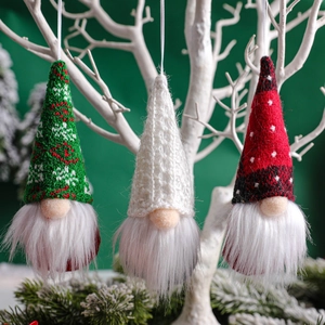 Three Christmas gnome ornaments with knitted hats hanging on a white decorative branch