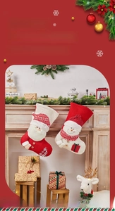 Close-up of festive Christmas stockings with Santa and snowman 3D plush on a fireplace