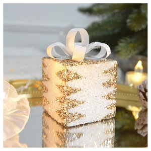 Close-up of golden and white sequined Christmas gift box lamp with silk bow ribbon detail