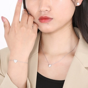 Minimalist silver heart jewelry set with necklace, bracelet and earrings on model