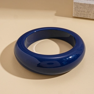 Détail d'un bracelet géométrique en résine bleu foncé brillant avec finition polie