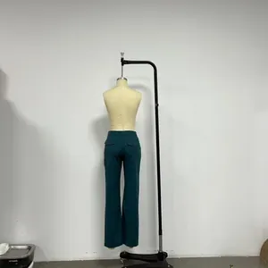 Detail of dark blue wide-leg denim trousers featuring back flap pockets on mannequin
