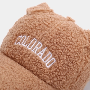 Close-up of white Colorado embroidery on brown teddy fleece baseball cap with ears