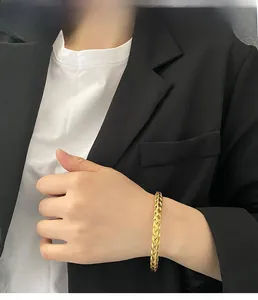 Detail view of gold woven braided texture bracelet in titanium steel for women