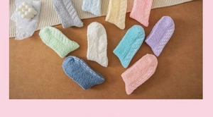 Detailed view of colorful non-slip coral fleece socks with wavy silicone grips on the bottom