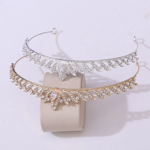 Detail showing silver and gold bridal crowns with sparkling zircon leaves on a display stand