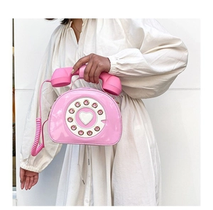 Close-up of pink vintage telephone-style handbag with glossy finish and retro rotary dial