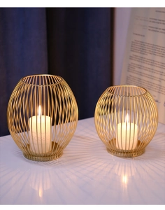 Detailed view of Nordic gold wire iron candle holders on white marble table