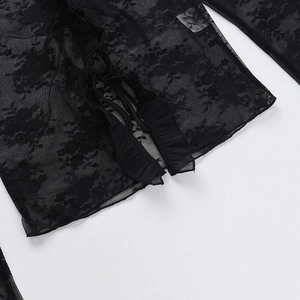 Détail du tissu en dentelle florale noire avec ourlet à volants délicat et maille fine