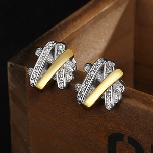 Macro view of gold and silver two-tone earrings with micro-pave cubic zirconia inlay
