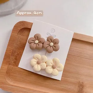Details von vier matten 4cm Blumen-Haarspangen in Braun und Creme auf einer Displaykarte