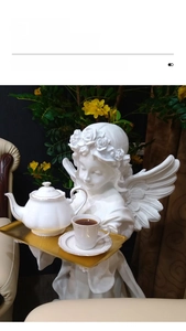 Detail of creative angel sculpture floor ornament with golden tray for home decor