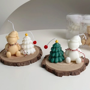 Detailed close-up of handmade Christmas tree and bear candles on rustic wooden base