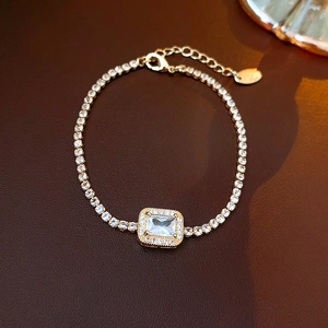 Vergulde tennisarmband met roze schelpbloem en een smaragd geslepen zirkonia steen