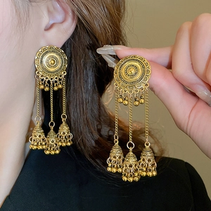 Detailed view of vintage ethnic crescent tassel earrings with golden jhumka bells style