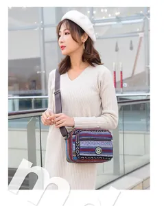 Close-up of woven canvas crossbody bag with colorful ethnic stripes and adjustable strap