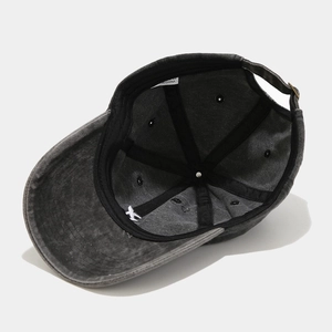 Detail view of washed dark grey baseball cap interior with reinforced seams and metal buckle