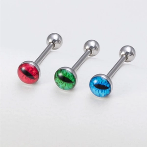 Macro shot of three stainless steel tongue rings with colorful red green blue cat eye balls
