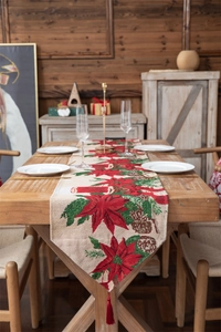 Detailed texture of Christmas table runner with poinsettia patterns and red tassels