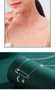 Detail view of S925 silver safety pin necklace with sparkling moon and star pendants