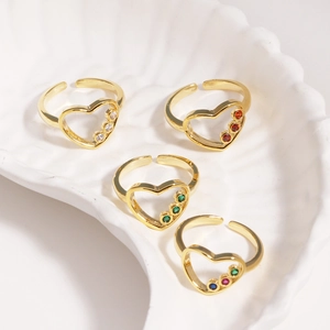 Détail de bagues cœur plaquées or 14 carats avec zircons colorés dans un plateau