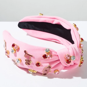 Dettaglio cerchietto rosa con strass, scritta Love e ciondolo a forma di cuore