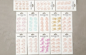 Flat lay of colorful novelty paper clips in various shapes like cat and flamingo
