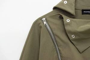 Detail of army green jacket featuring diagonal metal zipper and silver snap buttons