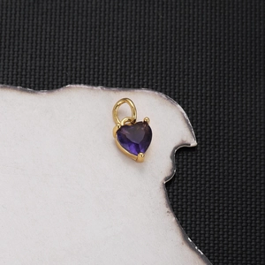 Macro detail of heart-shaped purple zircon pendant with gold-plated setting