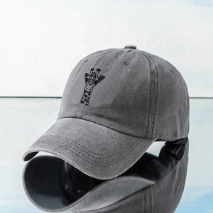 Detailed close-up of giraffe embroidery on a dark grey washed cotton baseball cap