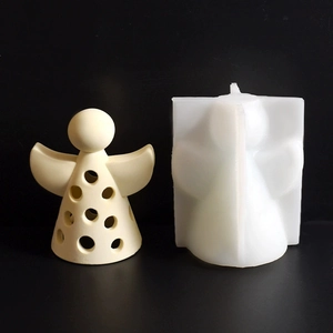 Detail of angel silicone mold next to a hollow decorative plaster angel ornament