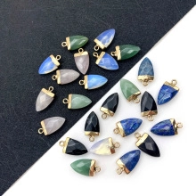 Assorted natural stone arrow pendants with gold metal bails on a dual-tone background