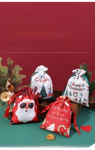 Detailed view of festive Christmas drawstring gift bags in a cozy holiday wood tray setting