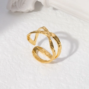 Close-up of golden irregular hammered texture adjustable open ring on white stone background