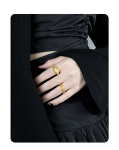 Detail of gold textured rings featuring vintage wave patterns on model's hand