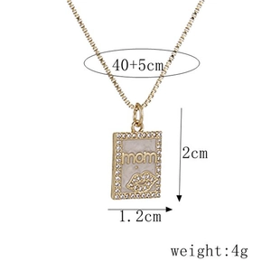 Gold MAMA pendant necklace with red lip motif and clear crystal border on white background