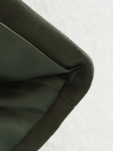Detailed macro view of dark olive green faux suede fabric with twill lining texture