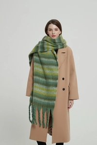 Detail of thick striped scarf with deep green ginger tassels and fluffy texture