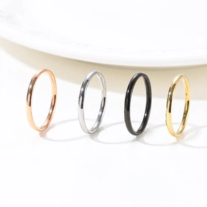 Set of four minimalist stainless steel rings in rose gold, silver, black, and gold colors