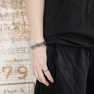 Close-up of men's silver hollow cross punk bracelet and matching ring set