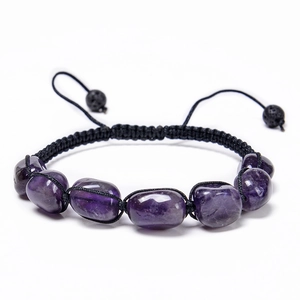 Detailed view of handmade purple amethyst bead with black woven cord and lava stone bead