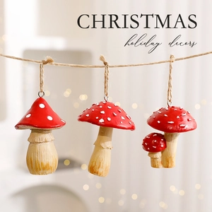 Three red and white polka dot mushroom Christmas ornaments hanging with rustic jute ropes