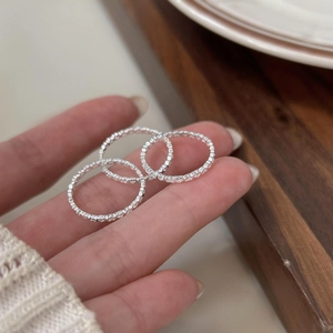 Three minimalist silver 925 heart-shaped hollow rings shown in a hand-held lifestyle shot