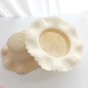 Detail of woven straw sun hat showing interior texture and elastic windproof strap