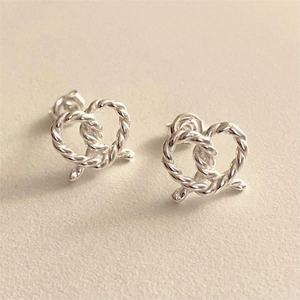 Macro detail of twisted rope texture on S925 silver heart-shaped knot stud earrings
