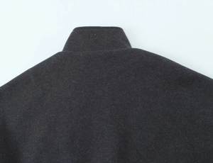 Detail of dark charcoal wool bomber jacket showing high-quality stitching on collar and shoulder