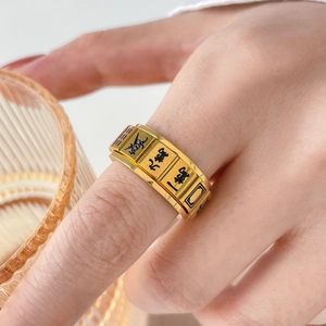 Close-up of golden mahjong rotatable ring with black engraved Chinese characters